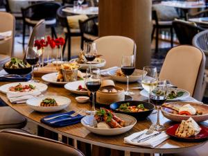 uma mesa com pratos de comida e copos de vinho em Novotel Sydney Darling Harbour em Sidney