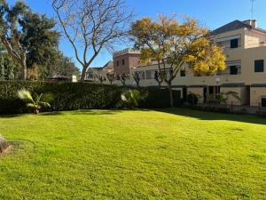 イスランティージャにあるPrecioso chalet adosado en Isla Antilla Huelvaの大きな家と芝生のフィールドのある広い庭