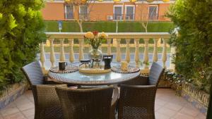 イスランティージャにあるPrecioso chalet adosado en Isla Antilla Huelvaのテーブル(椅子付)、花瓶(パティオ)