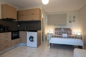 a kitchen with a bed and a washing machine at Elysian Studio in Kalamata