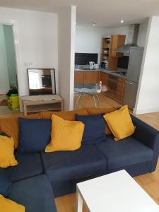 a blue couch with yellow pillows in a living room at Fab Manchester City new one bed apartment in Manchester