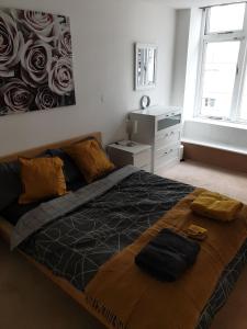 a bedroom with a large bed with a painting on the wall at Fab Manchester City new one bed apartment in Manchester