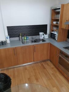 a small kitchen with a sink and a microwave at Fab Manchester City new one bed apartment in Manchester