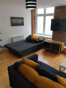 a living room with a bed and a couch at Fab Manchester City new one bed apartment in Manchester