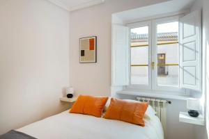 Dormitorio blanco con almohada naranja y ventana en Balcony of the Wall I 1min to avila's ALCAZAR, en Ávila 19 fotos más