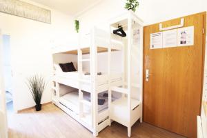 מיטה או מיטות קומותיים בחדר ב-Hotel Ulm Zentrum - Komplettes Zimmer, Hochbett, Android TV & eigenem Bad - perfekt für Familien & Gruppen