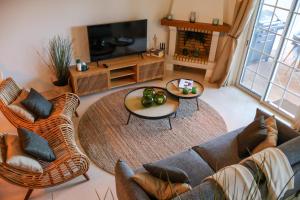uma sala de estar com um sofá e cadeiras e uma televisão em NEW! Quinta do Lago Golfside Retreat na Quinta do Lago