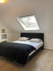 a bedroom with a large bed with a skylight at Vakantiewoning Duitsland in Freisen