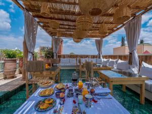 Riad Nelia De Marrakech Hotel Boutique & Spa في مراكش: منطقة طعام خارجية مع طاولة عليها طعام