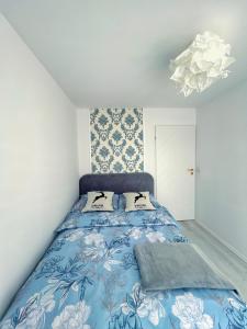 a bedroom with a blue bed with two pillows at Jaki tu spokój Domek w Bieszczadach in Wojtkowa