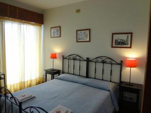 a bedroom with a bed with two lamps and a window at Casa Riccio in Palermo