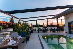 an outdoor patio with a pool and tables and chairs at Lilac Park Hotel in Tabuk