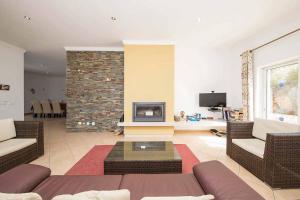 uma sala de estar com um sofá e uma lareira em Villa Belchior Nunes em Almargens