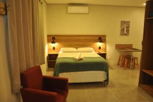 Habitación de hotel con cama y silla en Suite Negri, en Canela