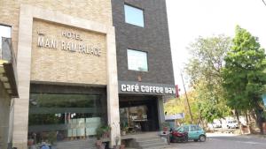 a building with a car parked in front of it at Hotel Mani Ram Palace,Agra in Agra