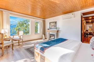 a bedroom with a bed and a desk and a window at SaffronStays Naiintara in Nainital