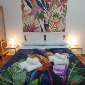 een bed met handdoeken en een muurschildering aan de muur bij MAISON PALU' in Napels