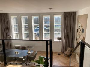 salon ze stołem, krzesłami i oknami w obiekcie Jutphaas Loft Appartement w mieście Nieuwegein