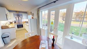 a kitchen and dining room with a table and a window at Willow Cottage - Part of the The Bay Filey Holiday Village with pool, gym and direct beach access, pub, restaurant, tennis and meadows walks in Reighton