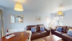 a living room with a couch and a table at Willow Cottage - Part of the The Bay Filey Holiday Village with pool, gym and direct beach access, pub, restaurant, tennis and meadows walks in Reighton
