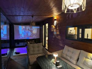 un soggiorno con divano e TV di Tiny House Bungalow - Pool, Jacuzzi, Winter Garden a Smirne