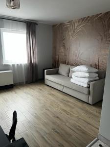 - un salon avec un canapé et une fenêtre dans l'établissement Delta Apart-House, à Wrocław