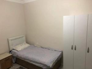 Dormitorio pequeño con cama y armario en Afyon Suit otel, en Afyon