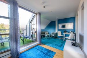 ein Wohnzimmer mit blauen Wänden und großen Fenstern in der Unterkunft Hotel Rivoli in München