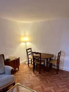 uma sala de estar com uma mesa e cadeiras e um sofá em Tea Time em Douvres-la-Délivrande
