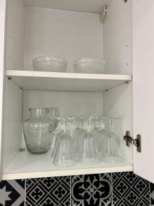 um armário branco com pratos de vidro em Tea Time em Douvres-la-Délivrande