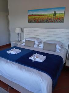 a large bed with towels and napkins on it at Lêplek Guest House in Saldanha