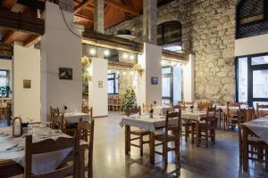 un restaurante con mesas y sillas y una pared de piedra en ALLE ANTICHE MINIERE - CASA VACANZE, en Zenich