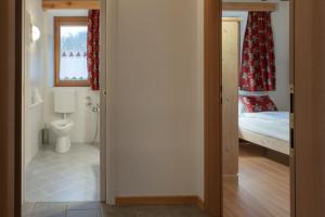 a bathroom with a toilet and a bed in a room at ALLE ANTICHE MINIERE - CASA VACANZE in Zenich