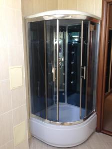 a glass shower in the corner of a bathroom at Pansionat Imperial in Kislovodsk