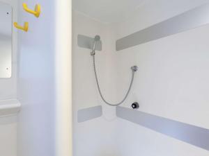 a shower with a hose attached to a wall at Hotel F1 Vesoul - En cours de rénovation in Vesoul