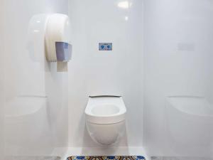 a white bathroom with a toilet and a phone at Hotel F1 Vesoul - En cours de rénovation in Vesoul