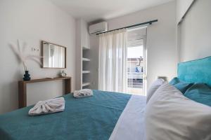 1 dormitorio con 1 cama con 2 toallas en Archangelos SKY Garden Apartment en Archangelos