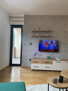 sala de estar con TV de pantalla plana en la pared en Zeleni Raj, en Zlatibor