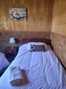 Una cama o camas en una habitación de Cabañas Vientos del Sur en Puerto Puyuhuapi Aysen