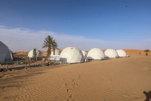 a row of domes in the middle of a desert at Ciel D'Etoile Sahara in Merzouga