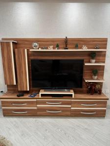 Un grand centre de divertissement en bois avec une télévision à écran plat est disponible. dans l'établissement Квартира, à Baku