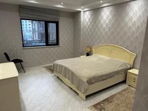 - une chambre avec un lit et une fenêtre dans l'établissement Квартира, à Baku