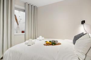 a white bed with a tray of fruit on it at King bed - Renovated 2024 - 2BR Behind Bryggen in Bergen