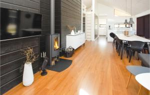 a living room with a fireplace and a dining room at Awesome Home In Haderslev With Kitchen in Kelstrup