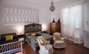 sypialnia z łóżkiem i krzesłami w pokoju w obiekcie Beatrice Luxury Apartment w mieście Vietri sul Mare