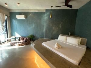 a bedroom with a large bed and a green wall at Happiness Kulambo Villa El Nido in El Nido