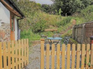 een houten hek met een tafel in een tuin bij The Hide at Lemons Farm in Atherington