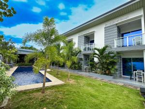 an exterior view of a house with a swimming pool and palm trees at Sapphire Boutique Resort in Panglao