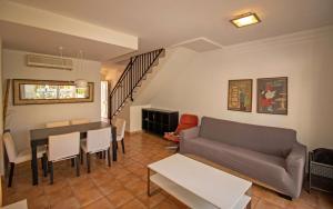 - un salon avec un canapé et une table dans l'établissement Adosado con jardin y piscina Palm Beach 86 ALBERT VILLAS, à Alcossebre