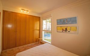 Postel nebo postele na pokoji v ubytování Adosado con jardin y piscina Palm Beach 86 ALBERT VILLAS